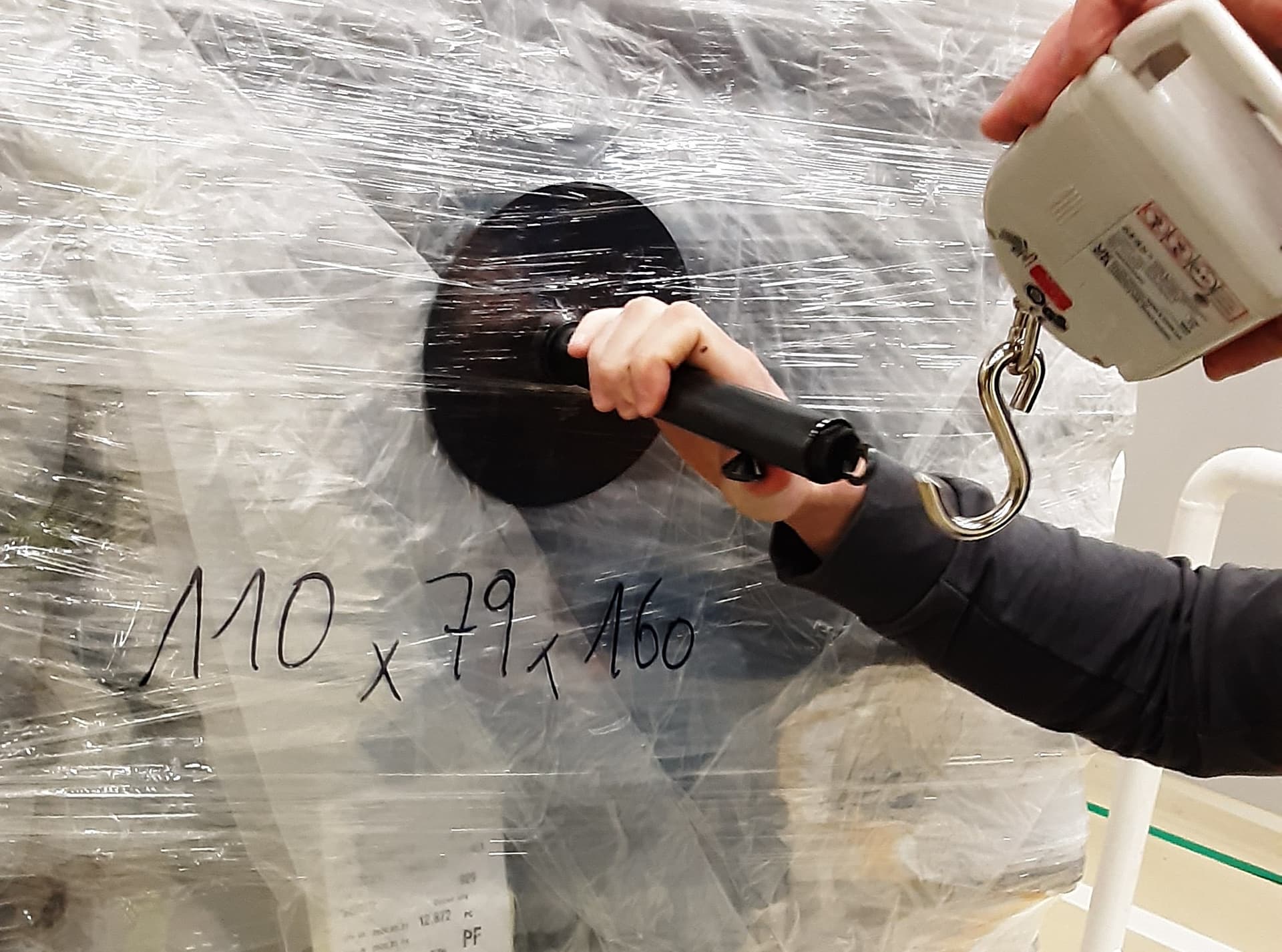 Measuring holding force on a wrapped pallet with a digital scale